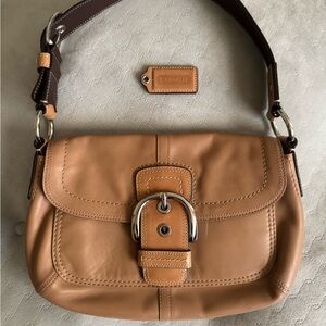 Coach Soho Saddle handbag in camel-colored leather.